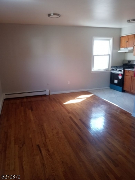 a view of a livingroom with wooden floor and a window