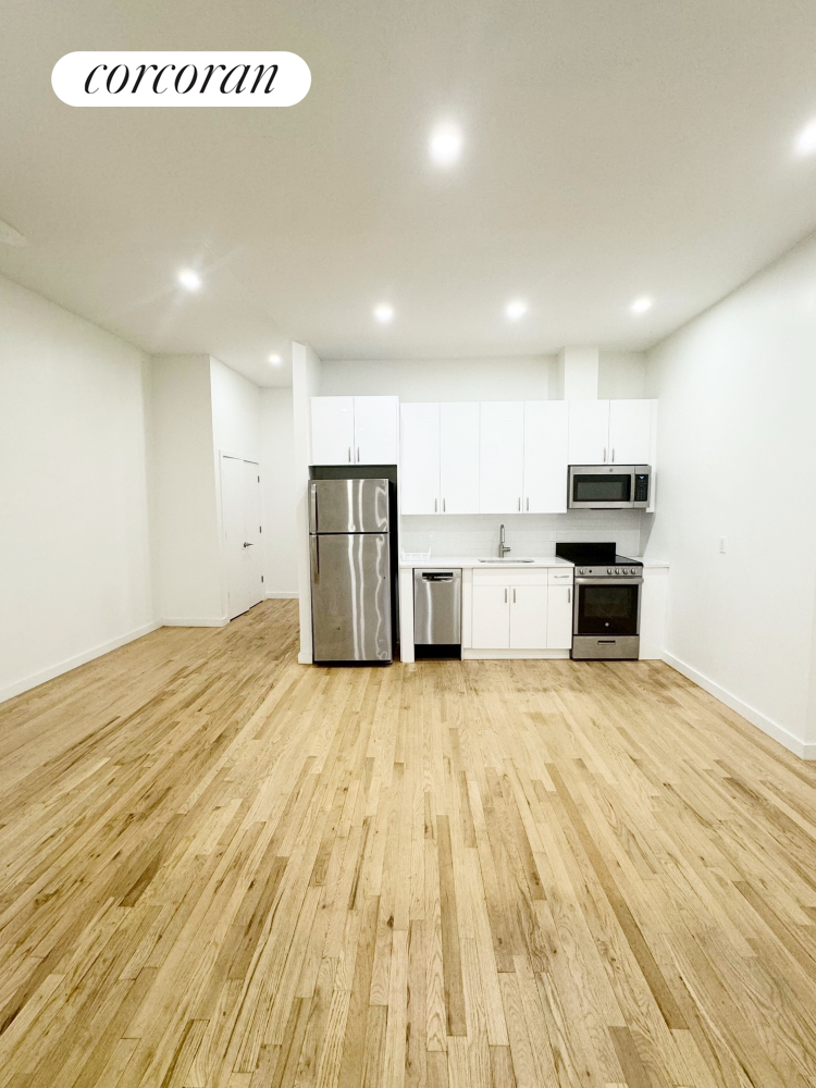 a view of a kitchen with a sink and a refrigerator