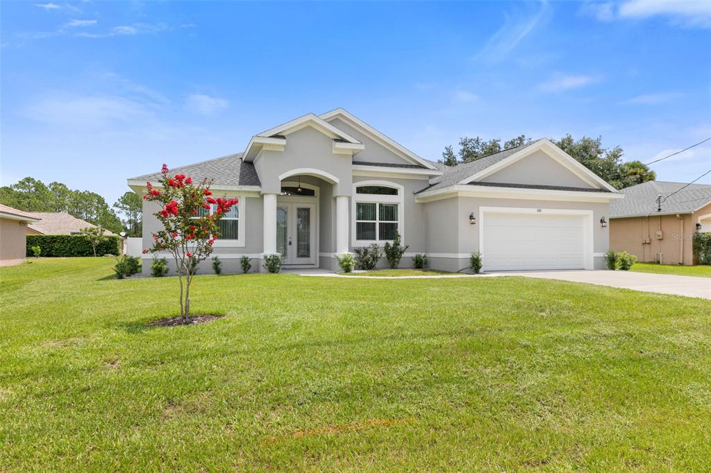 a front view of a house with a yard and garage