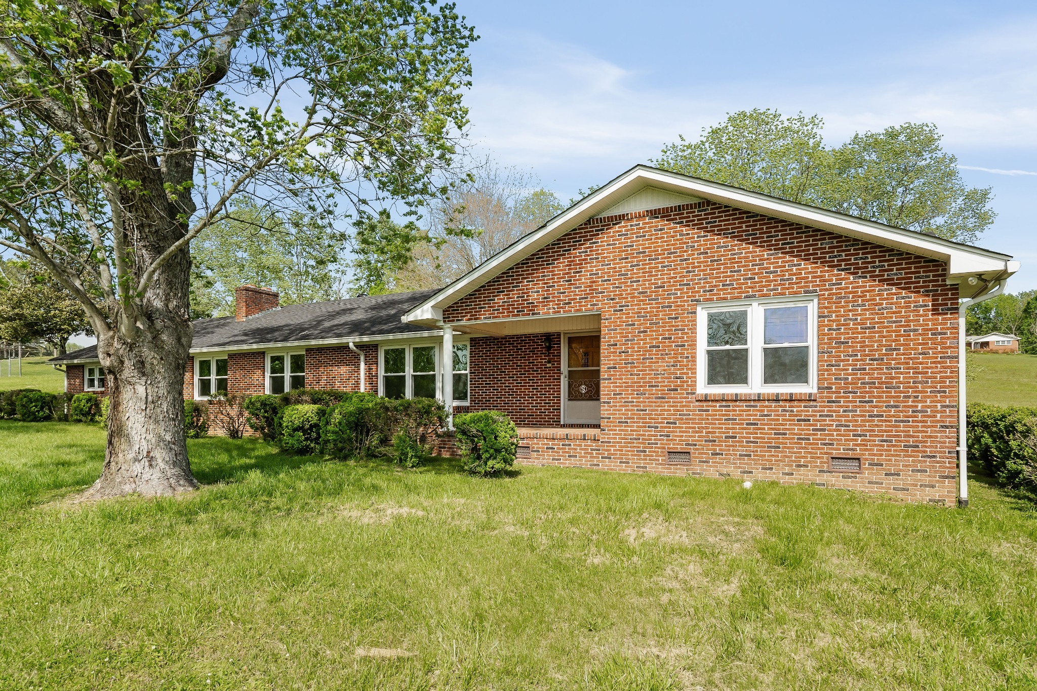 a front view of house with yard and trees around