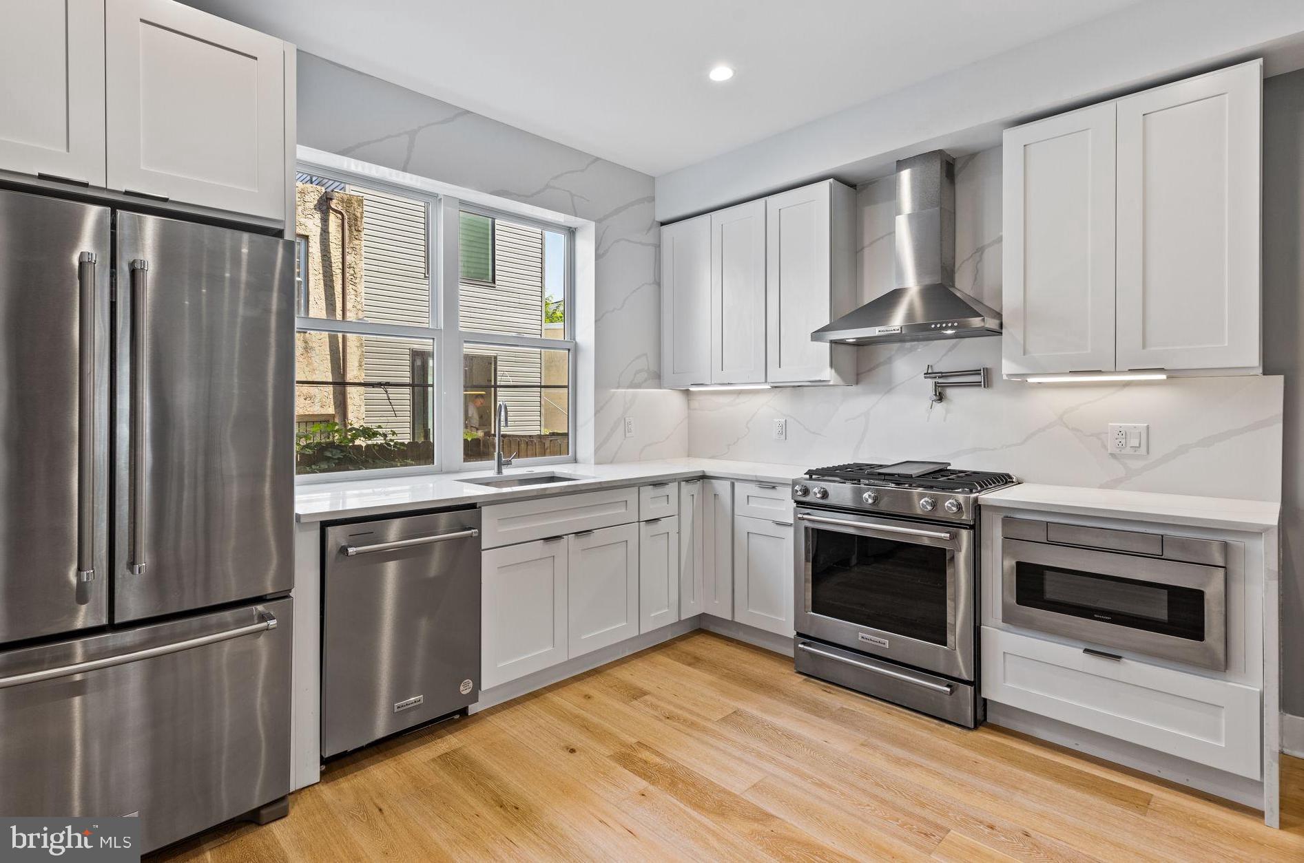 a kitchen with stainless steel appliances granite countertop a stove a refrigerator and a sink