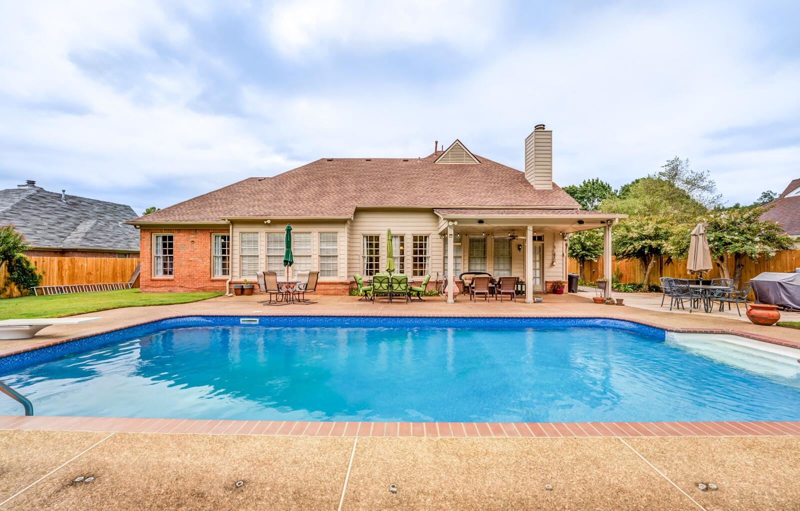 a front view of a house with swimming pool having outdoor seating