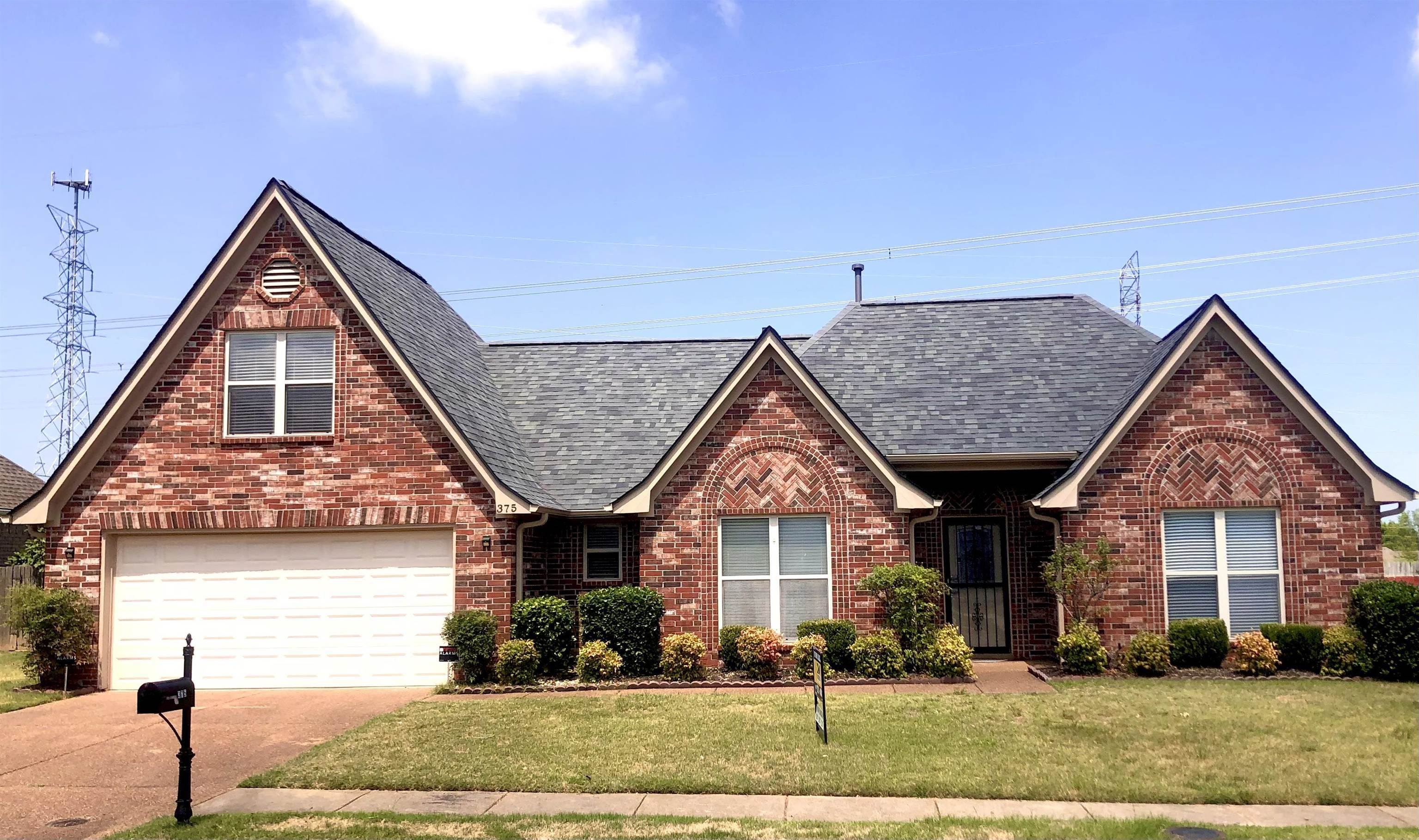 View of front of home with a garage and a front lawn