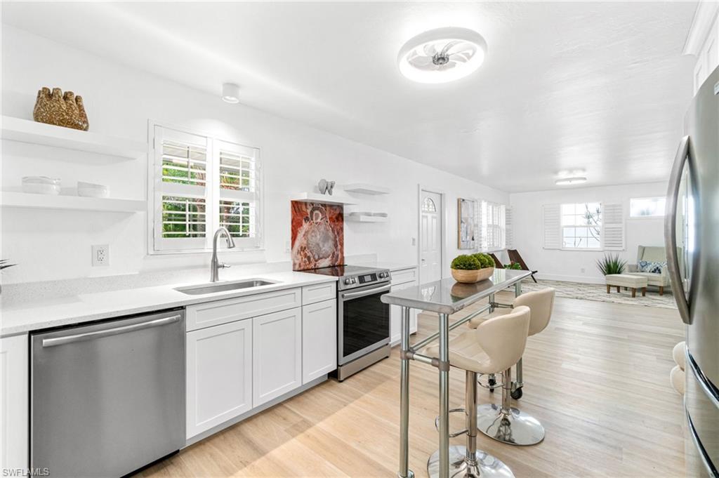 a open kitchen with stainless steel appliances granite countertop a stove and a sink