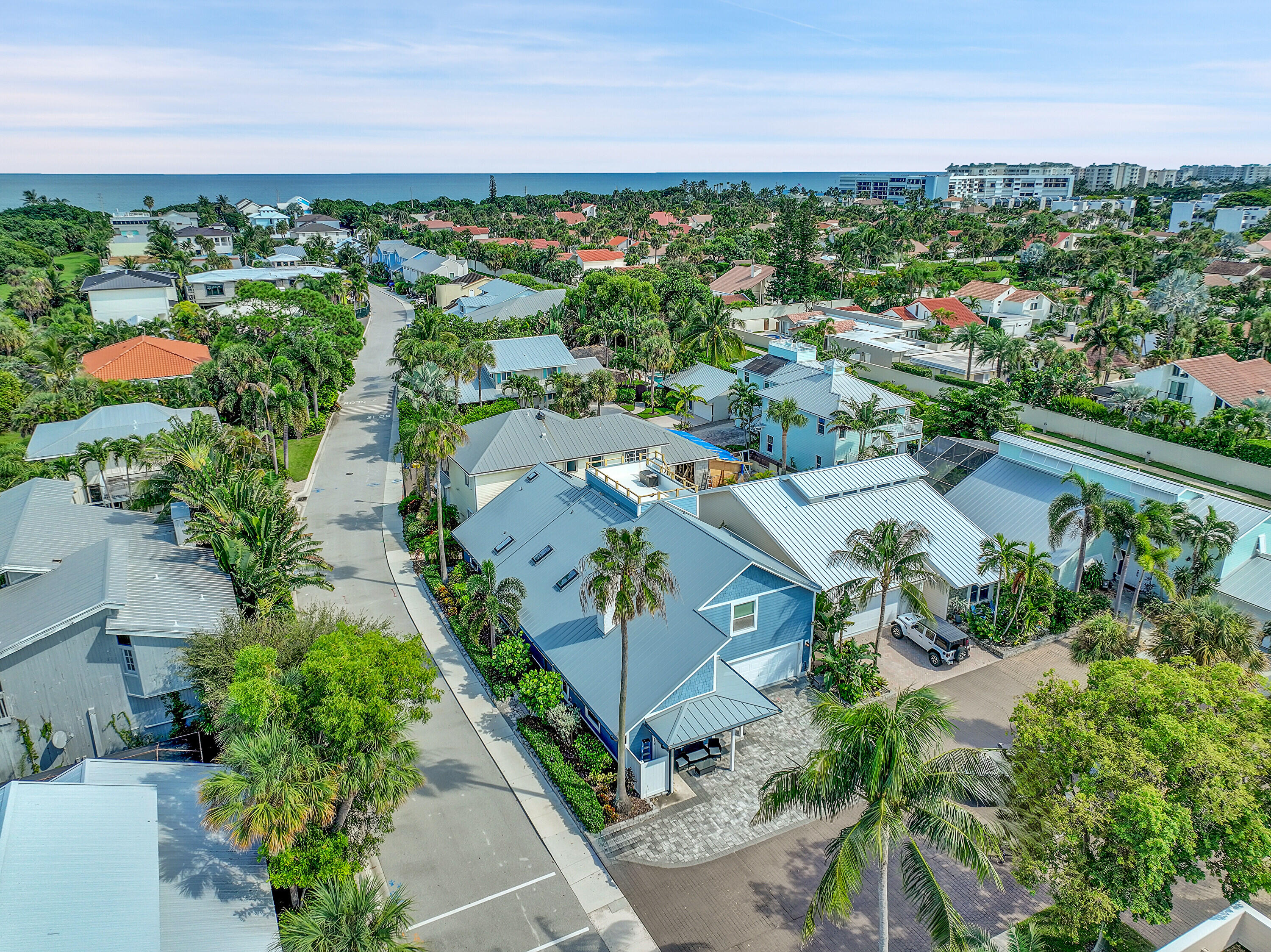 an aerial view of a city with lots of residential buildings ocean and mountain view in back