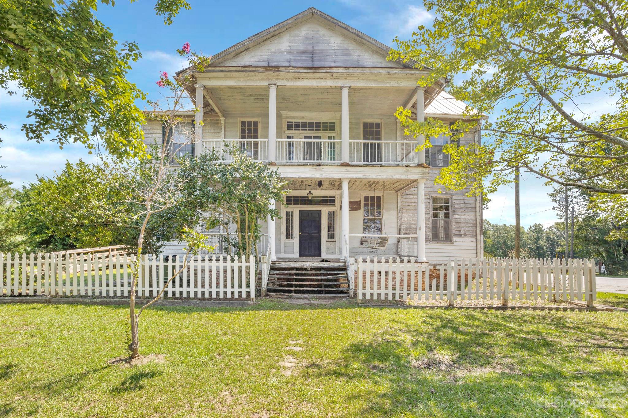 a view of a house with a small yard and wooden fence