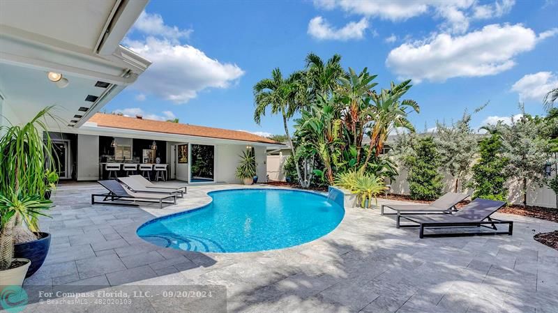 a view of a house with swimming pool and sitting area