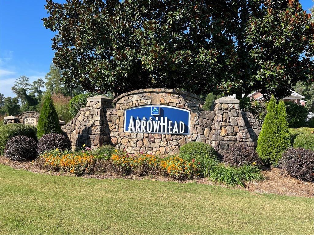 a sign of golf club on a wall under a tree