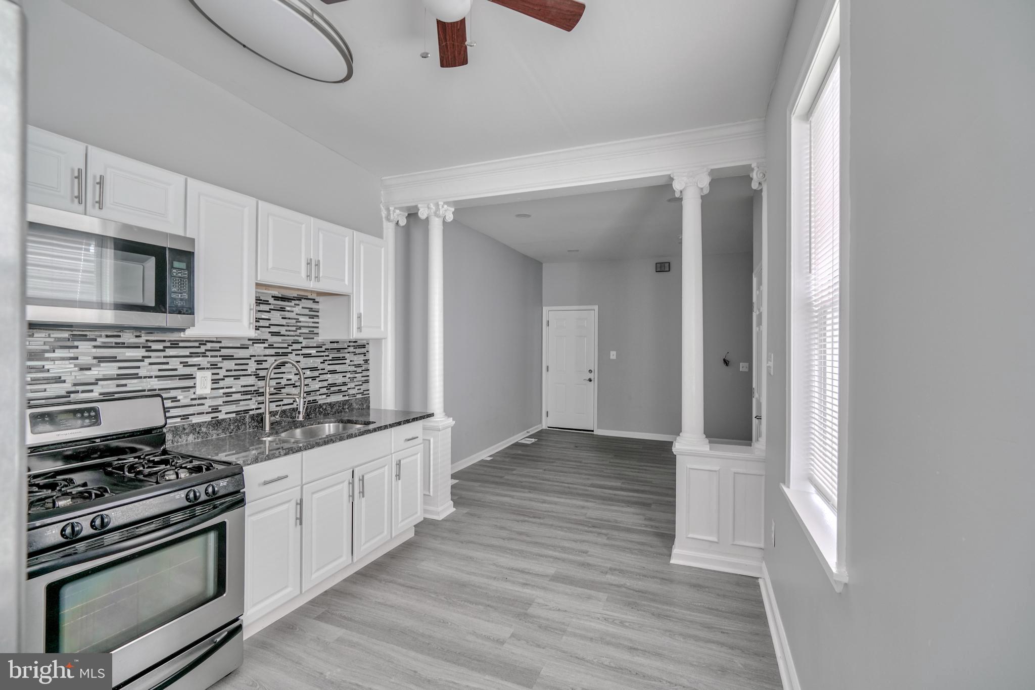 a kitchen with granite countertop a stove and a sink