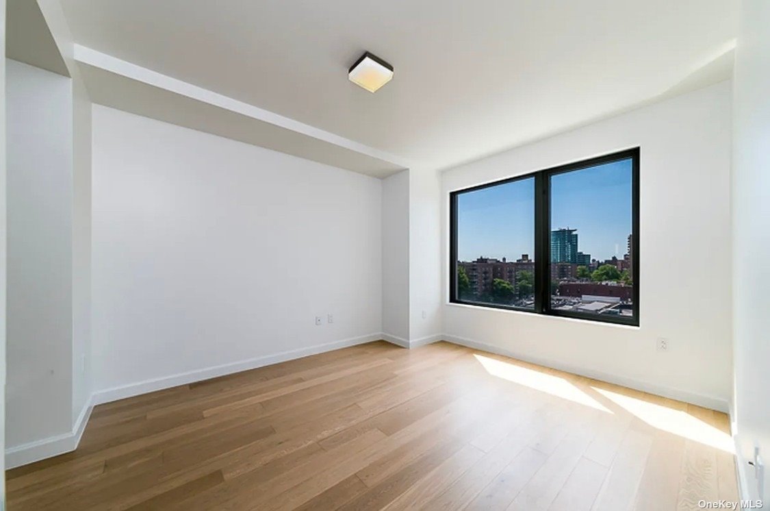 a view of a big room with wooden floor and windows