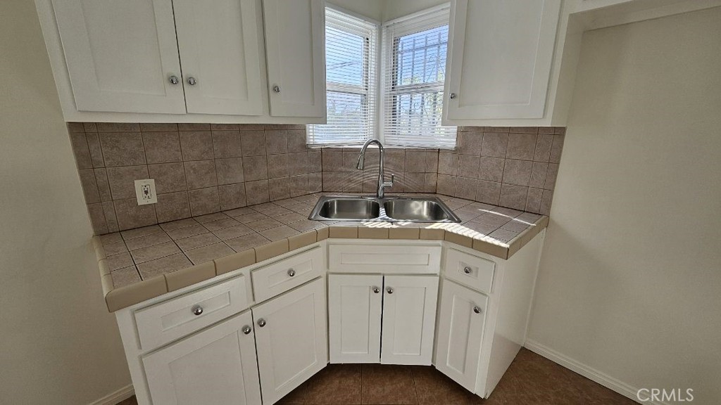 a kitchen with white cabinets sink and dishwasher