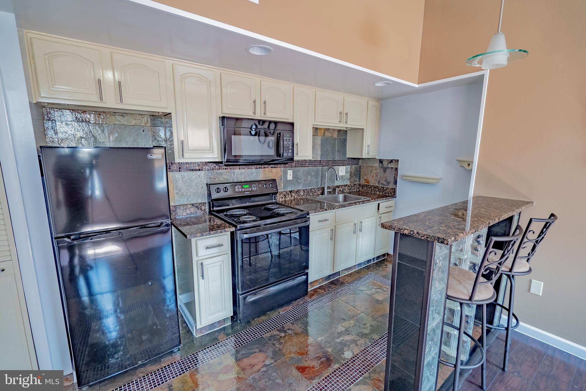 a kitchen with stainless steel appliances a refrigerator stove microwave and sink