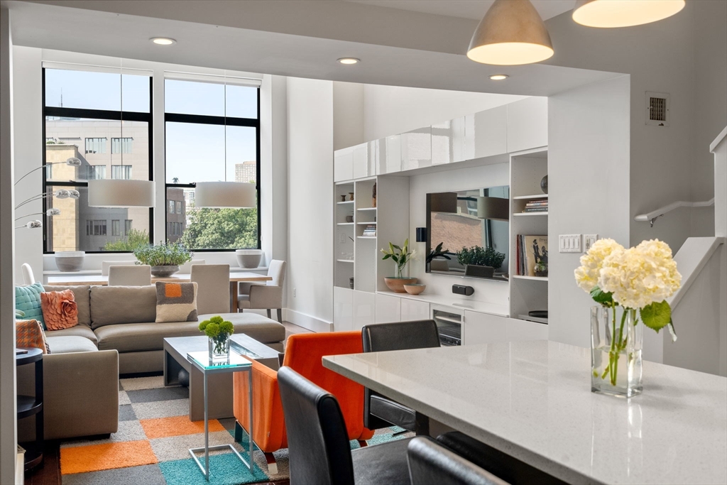 a dining room filled chandelier and kitchen view