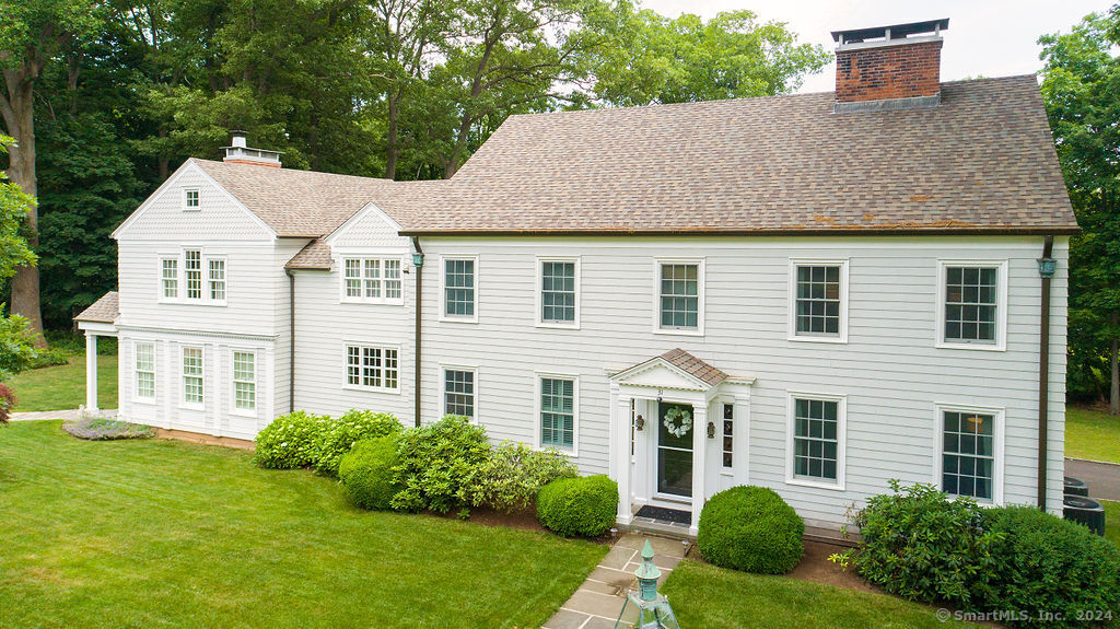 a view of a white house with a yard and plants