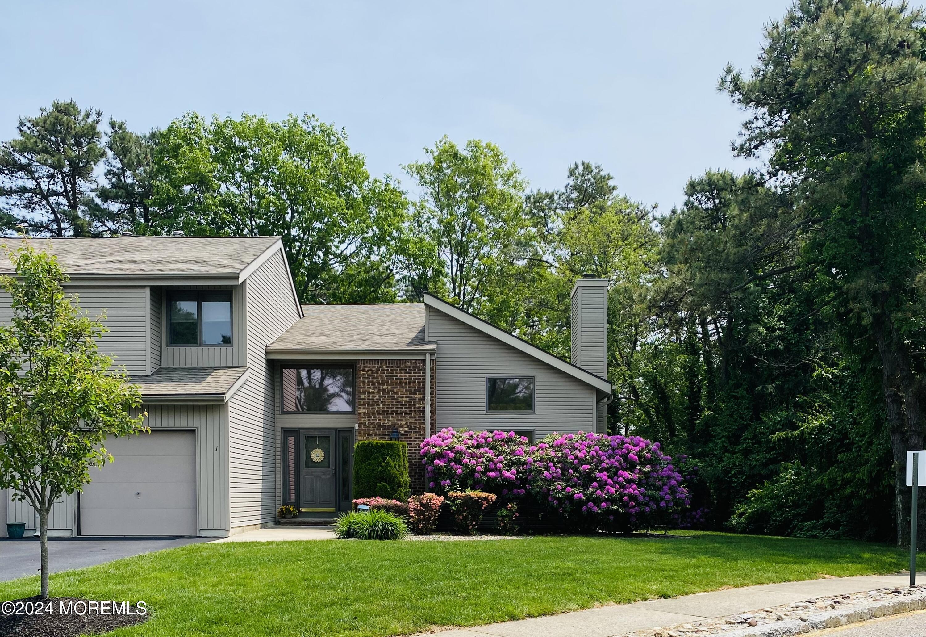 a front view of house with a garden