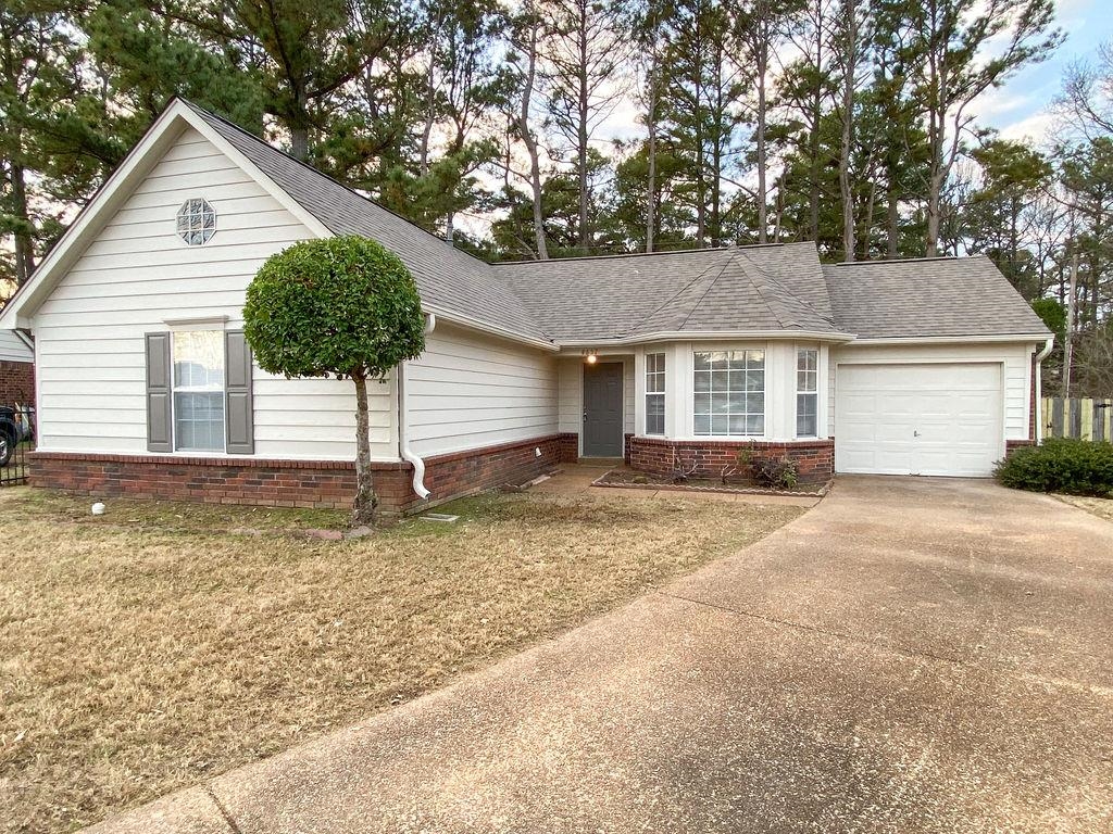 View of front facade featuring a garage and a front lawn