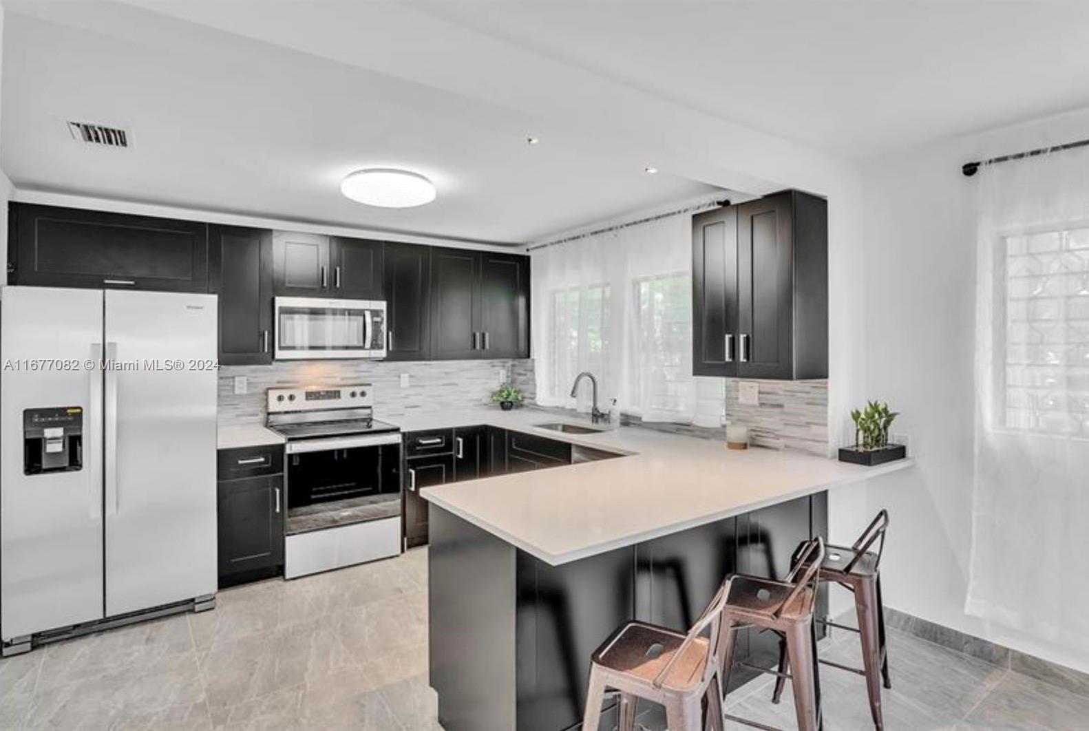 a kitchen with a stove a sink and a refrigerator