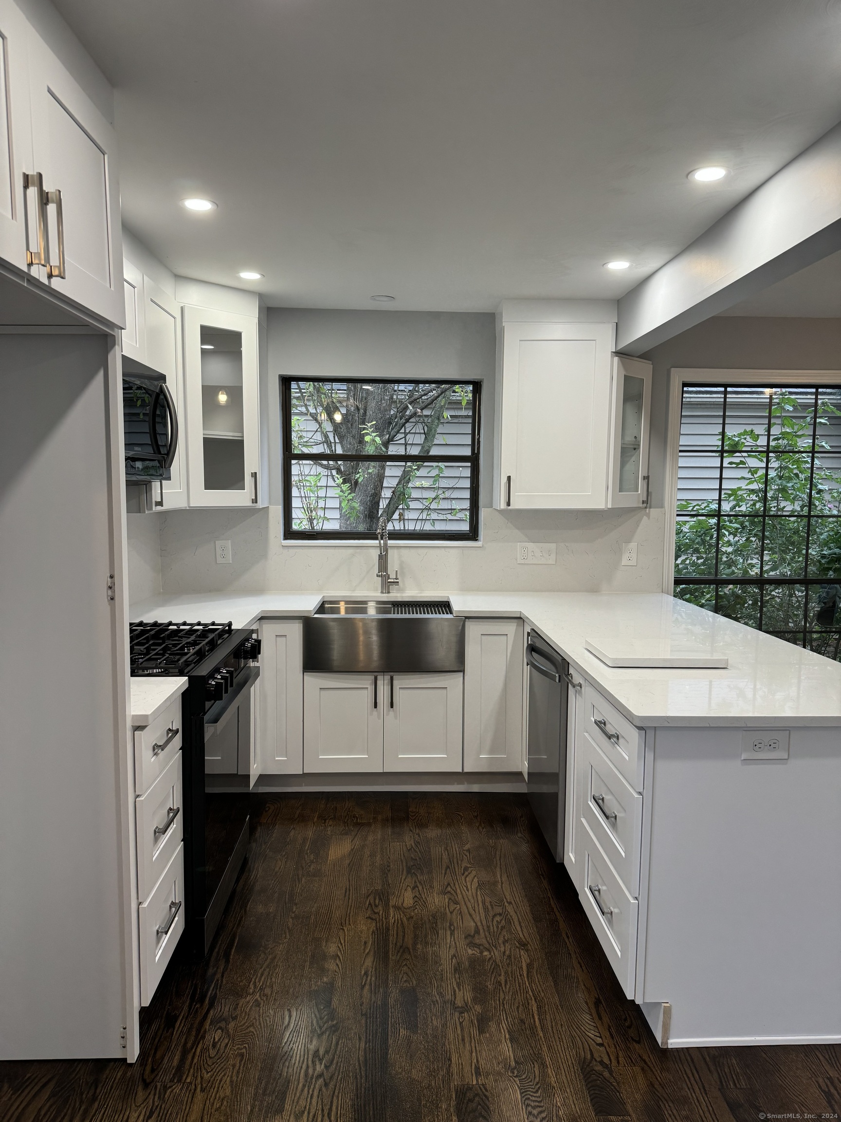 a kitchen with granite countertop white cabinets and white appliances