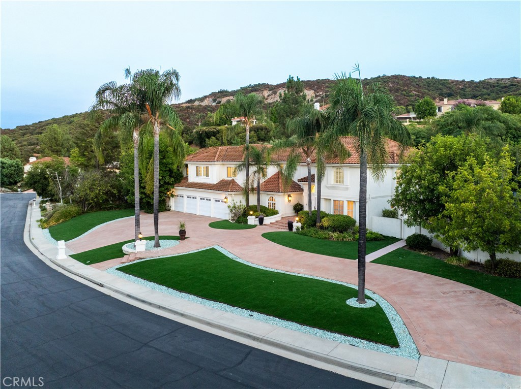 a view of a house with a yard and palm tree