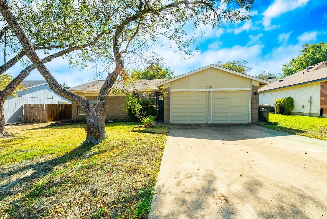 a view of a house with backyard and trees