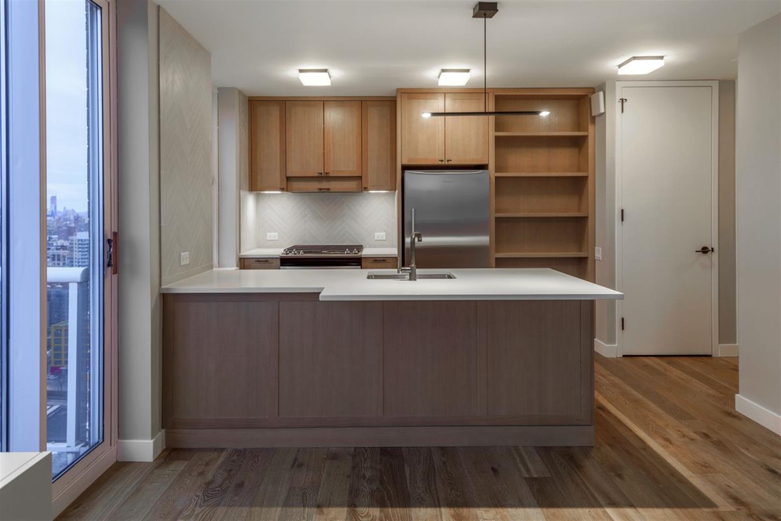 a kitchen with kitchen island a counter top space a sink and refrigerator