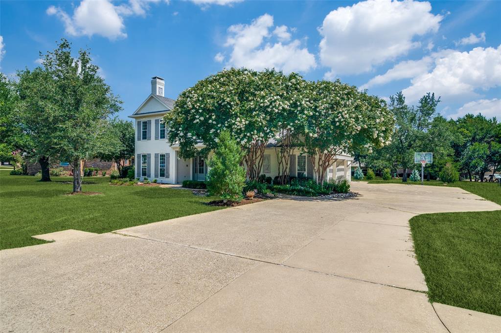 a view of a house with a yard and large tree