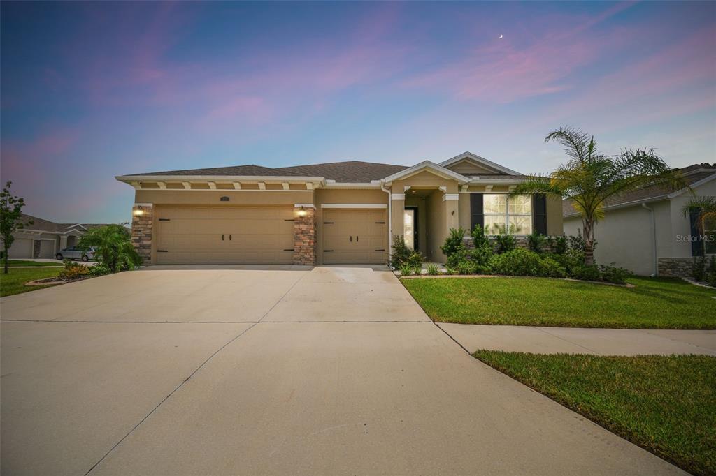 a front view of a house with a yard and a garage