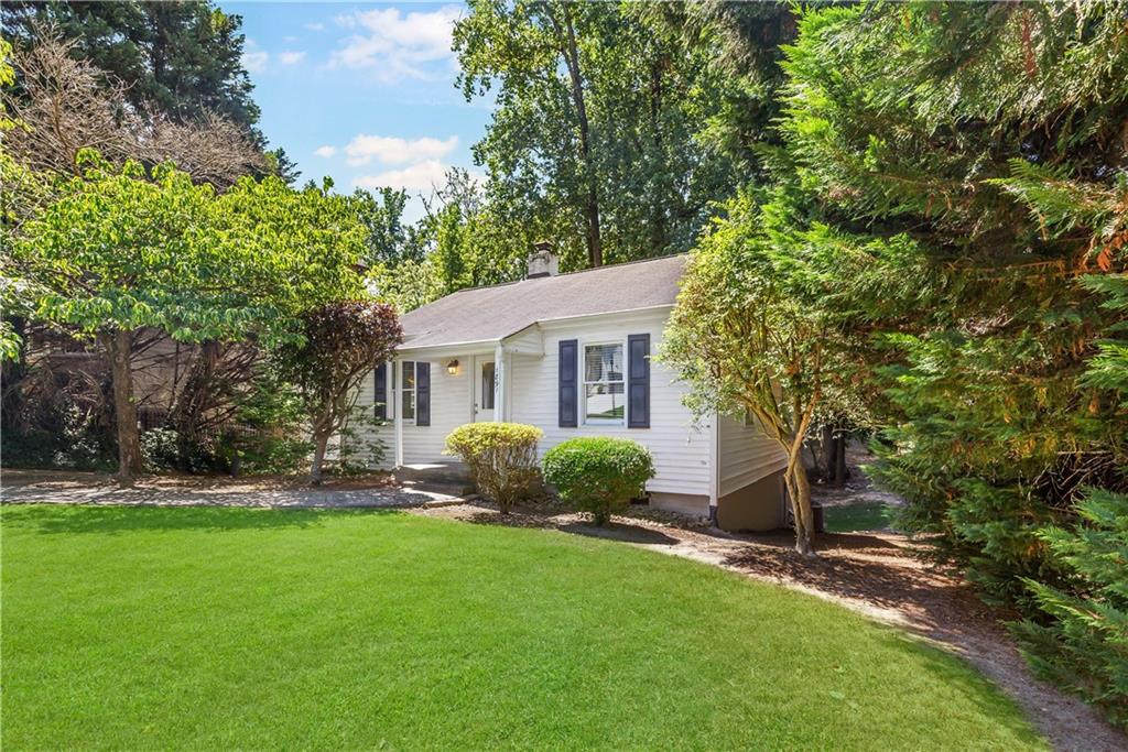 a front view of a house with a yard and trees