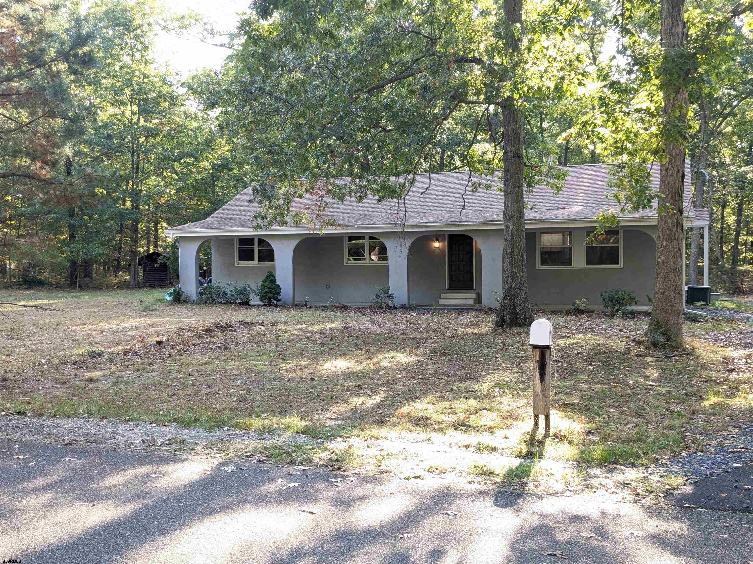 a front view of a house with a tree