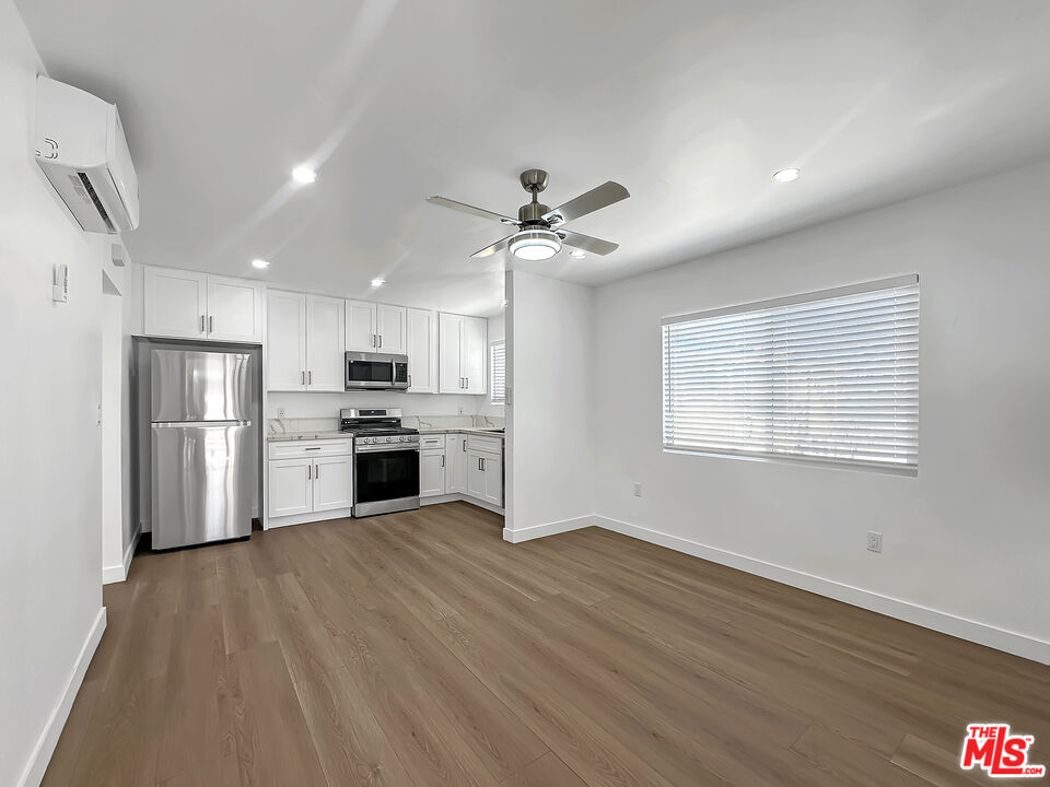 a view of a kitchen with wooden floor and a kitchen