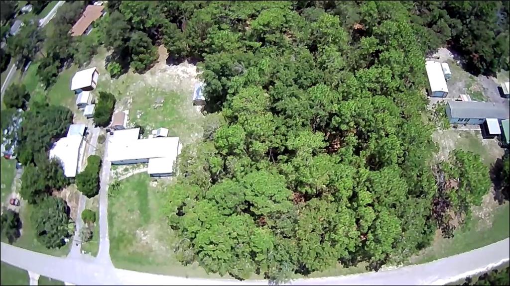 an aerial view of residential house with outdoor space and trees all around