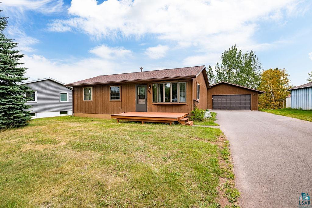 Single story home featuring a garage, an outdoor structure, and a front yard