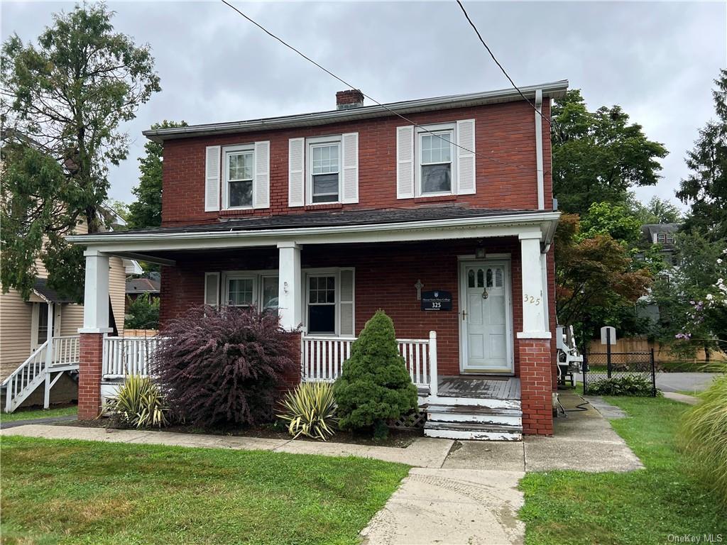 View of front facade with covered porch and a front yard