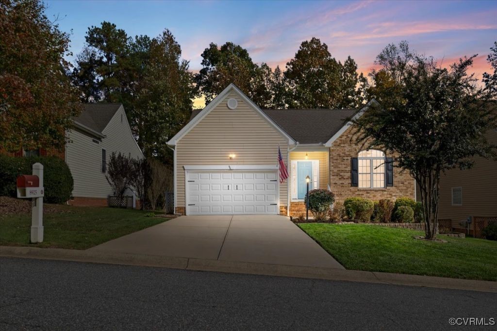 View of front of house with a yard and a garage