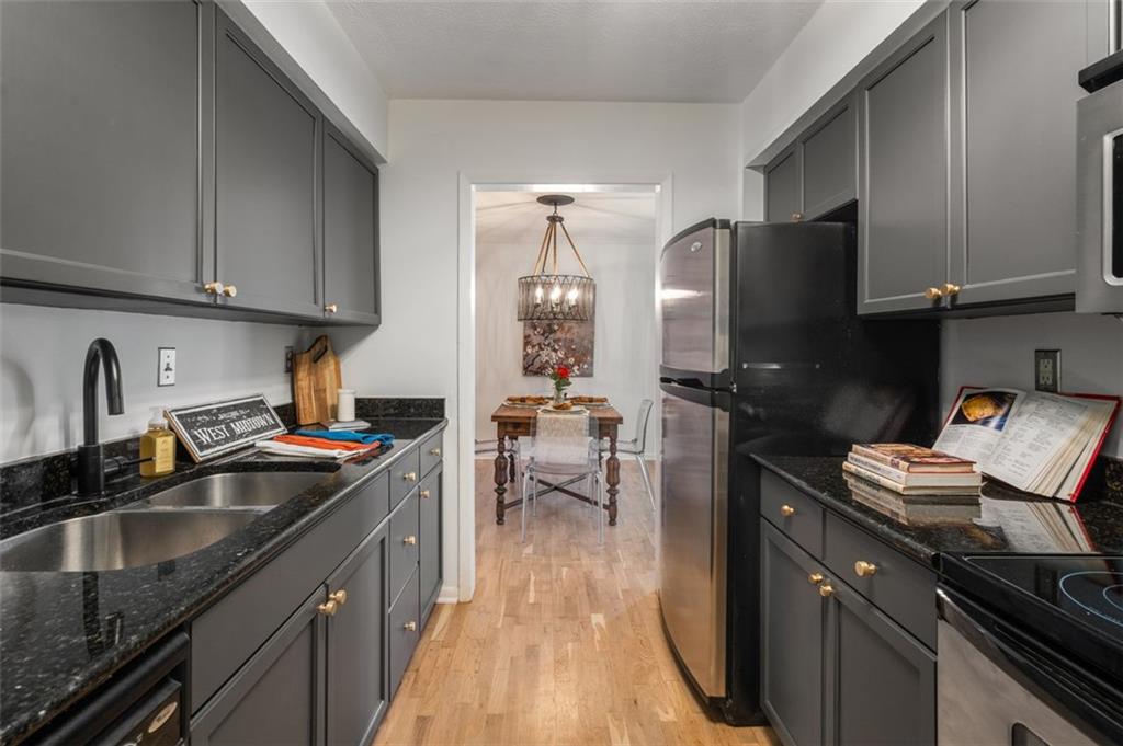 a kitchen with granite countertop a sink stove and refrigerator