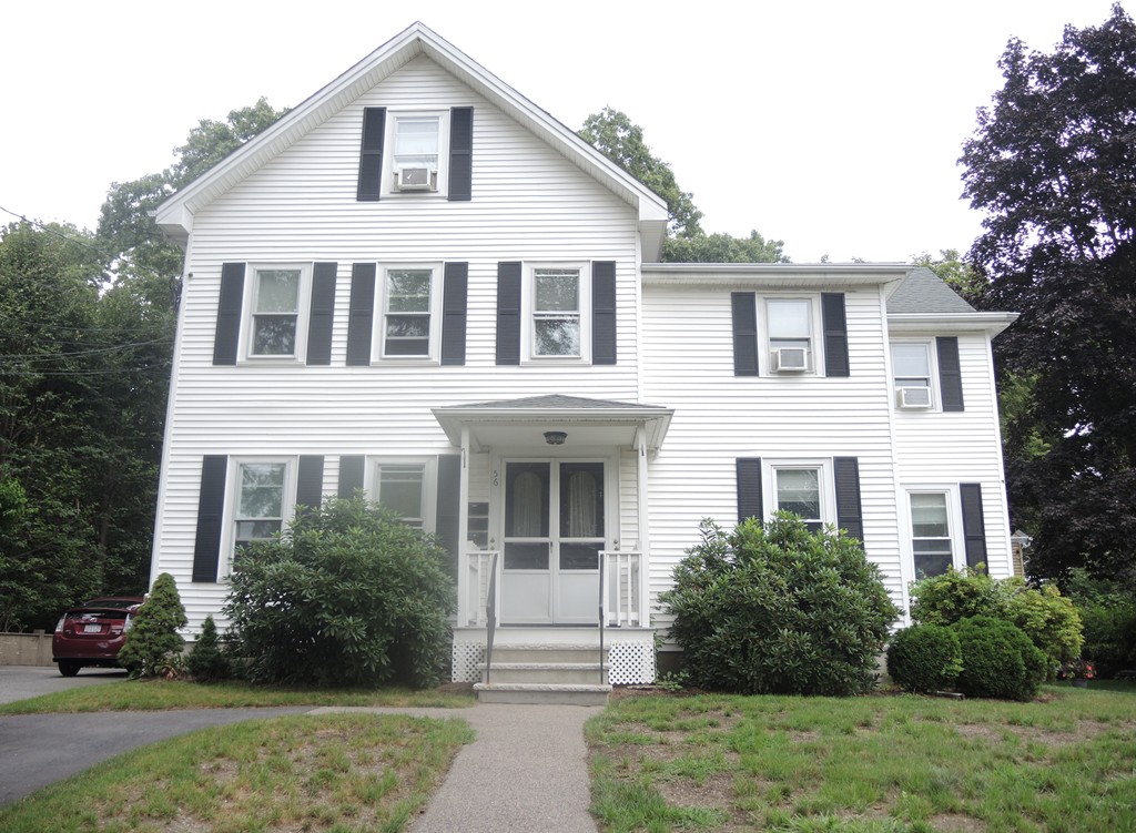 a front view of a house with a yard and trees