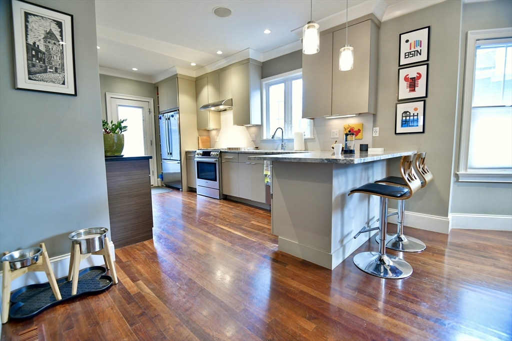 a living room with kitchen island furniture and a wooden floor