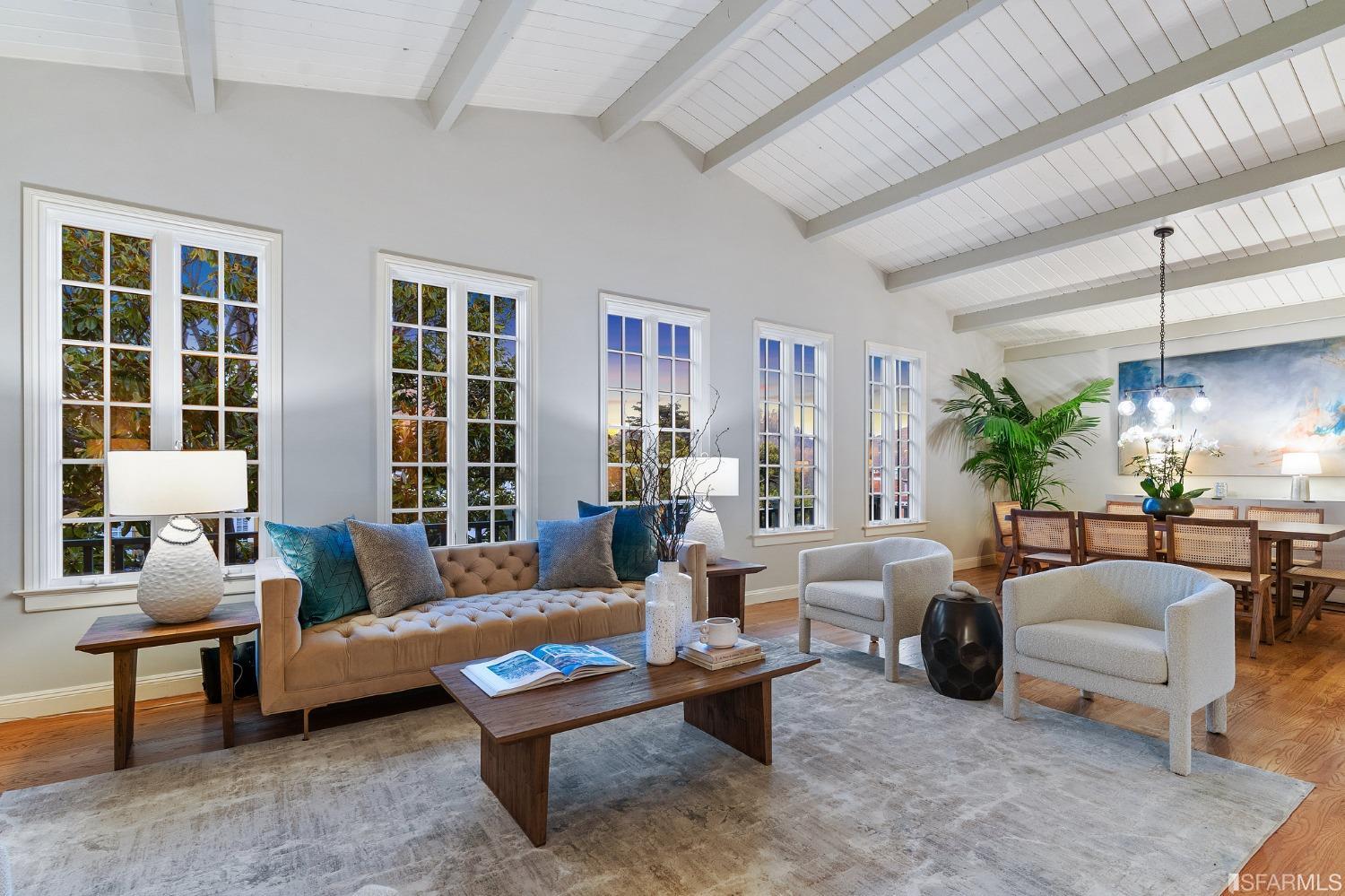 a living room with furniture potted plant and a large window