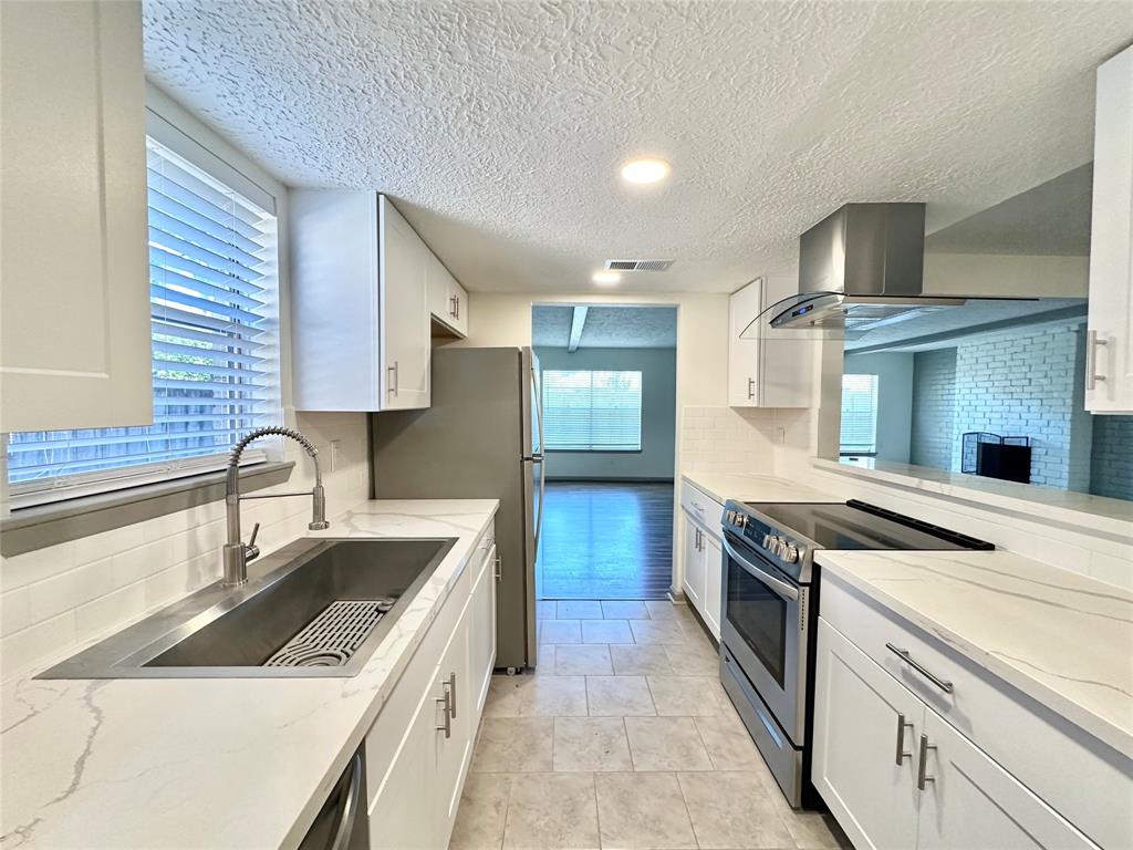 a kitchen with granite countertop a sink stainless steel appliances and cabinets