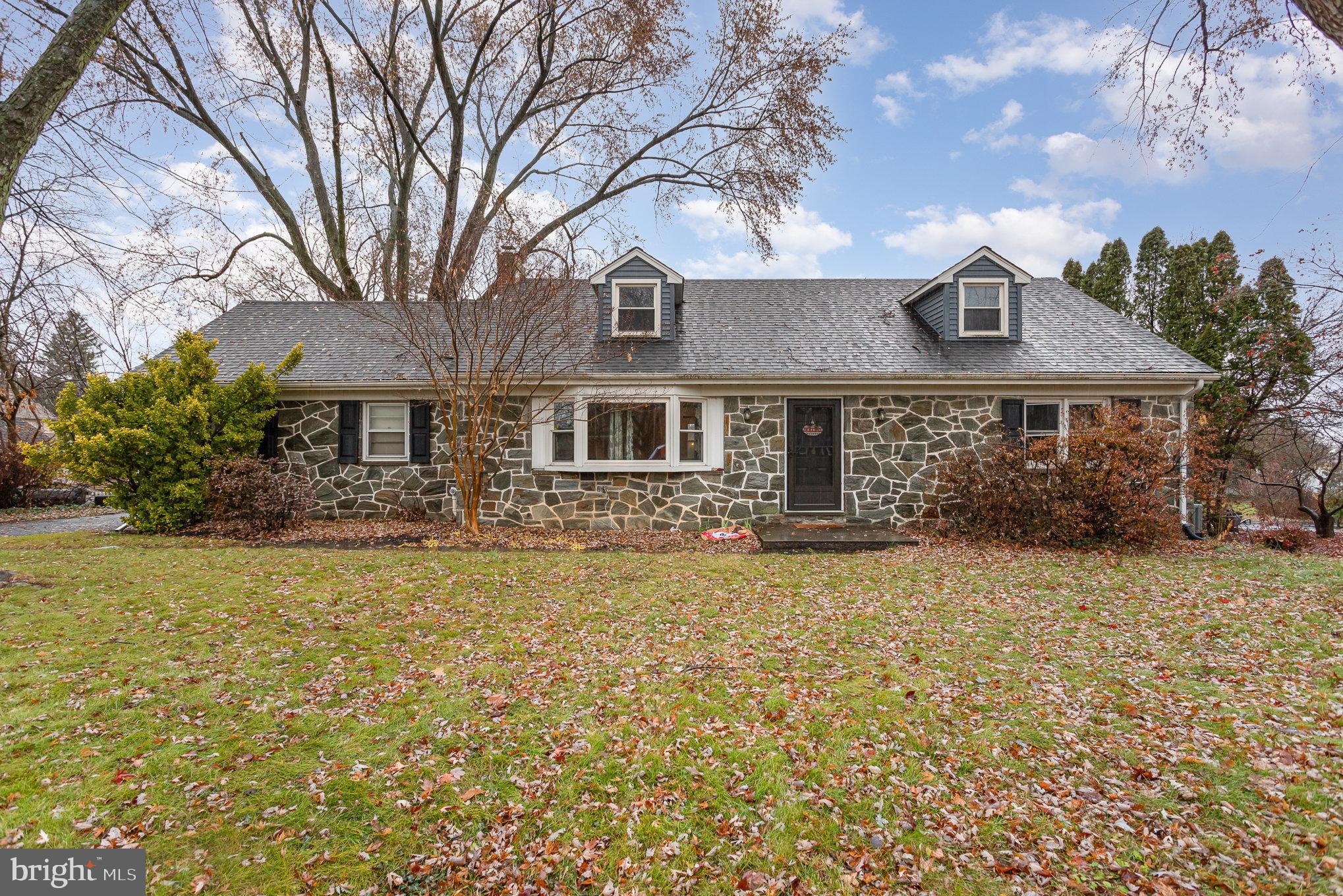 a front view of a house with a garden and tree