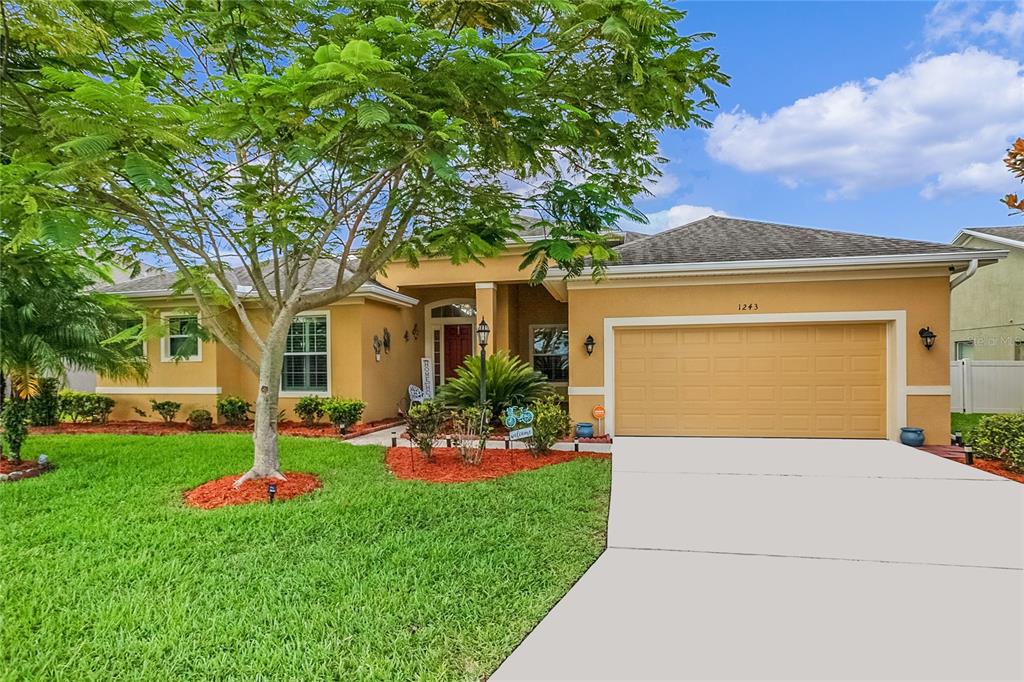 a front view of a house with yard and green space