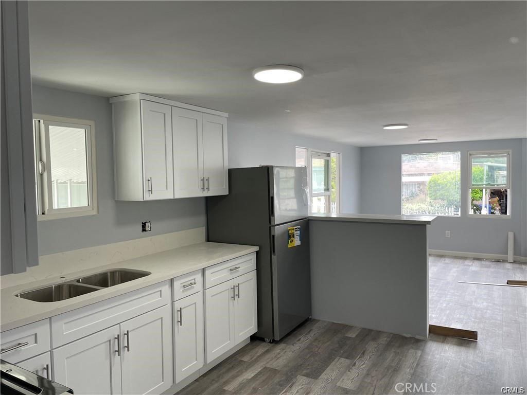 a kitchen with a sink cabinets and wooden floor