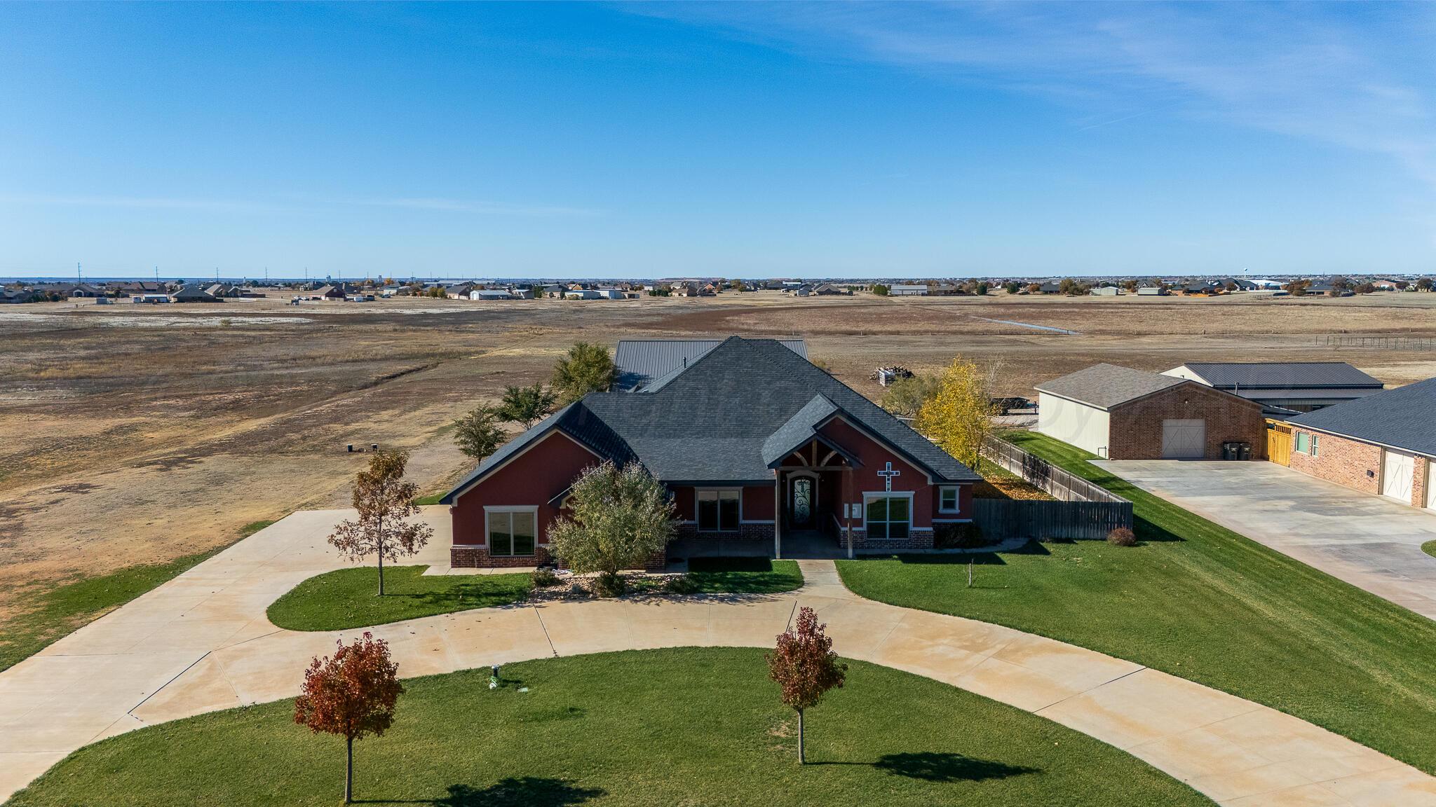 an aerial view of a house with a yard and lake view