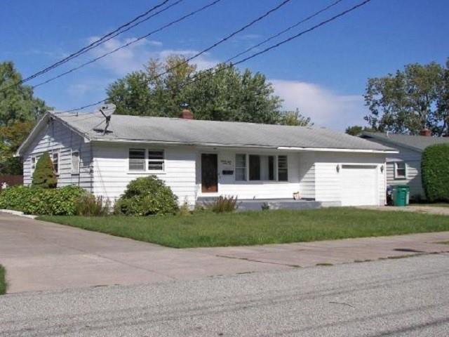 a front view of a house with a garden and yard