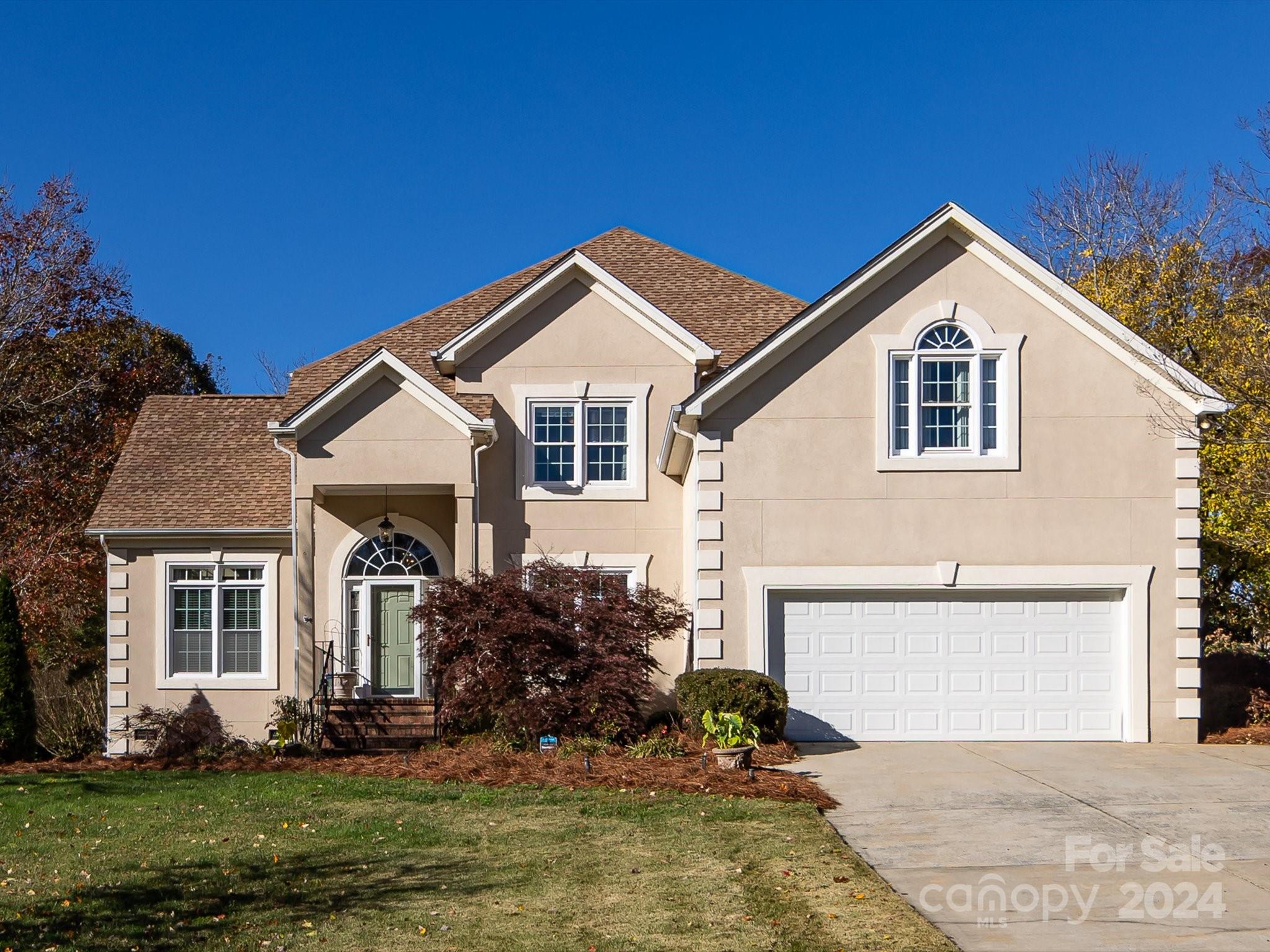 a front view of a house with a yard and garage