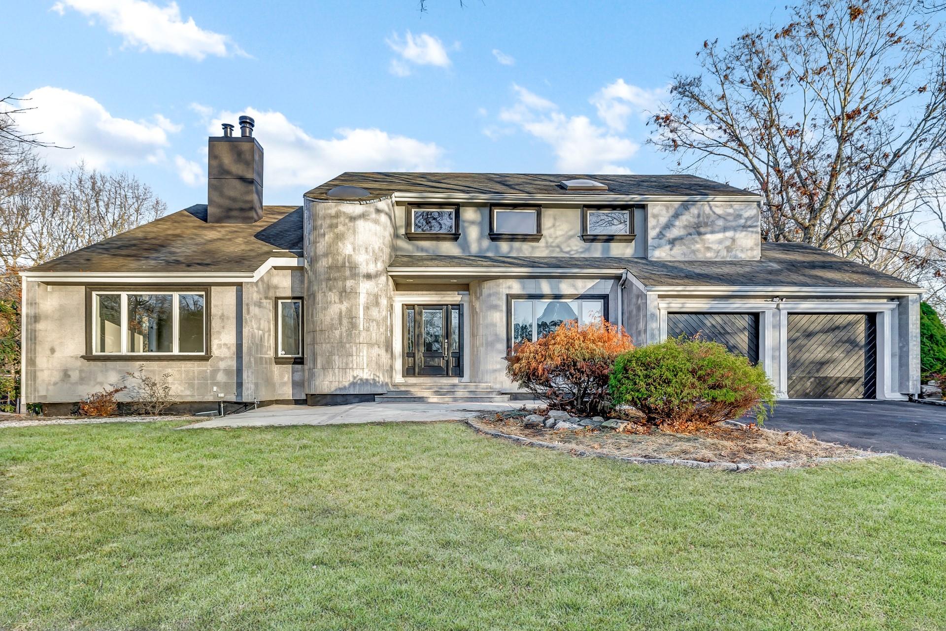 View of front of house with a front lawn and a garage