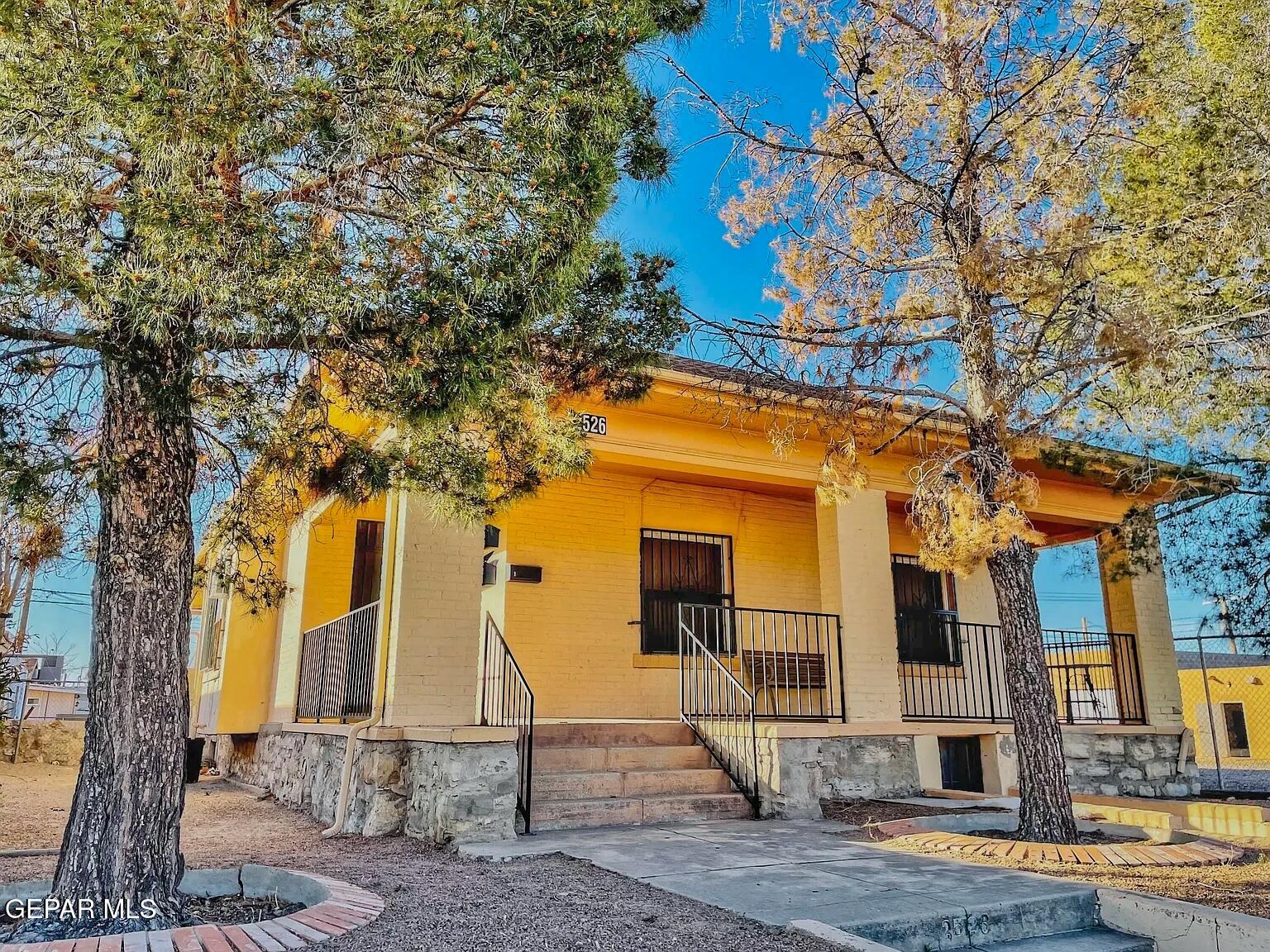 a front view of a house with a tree