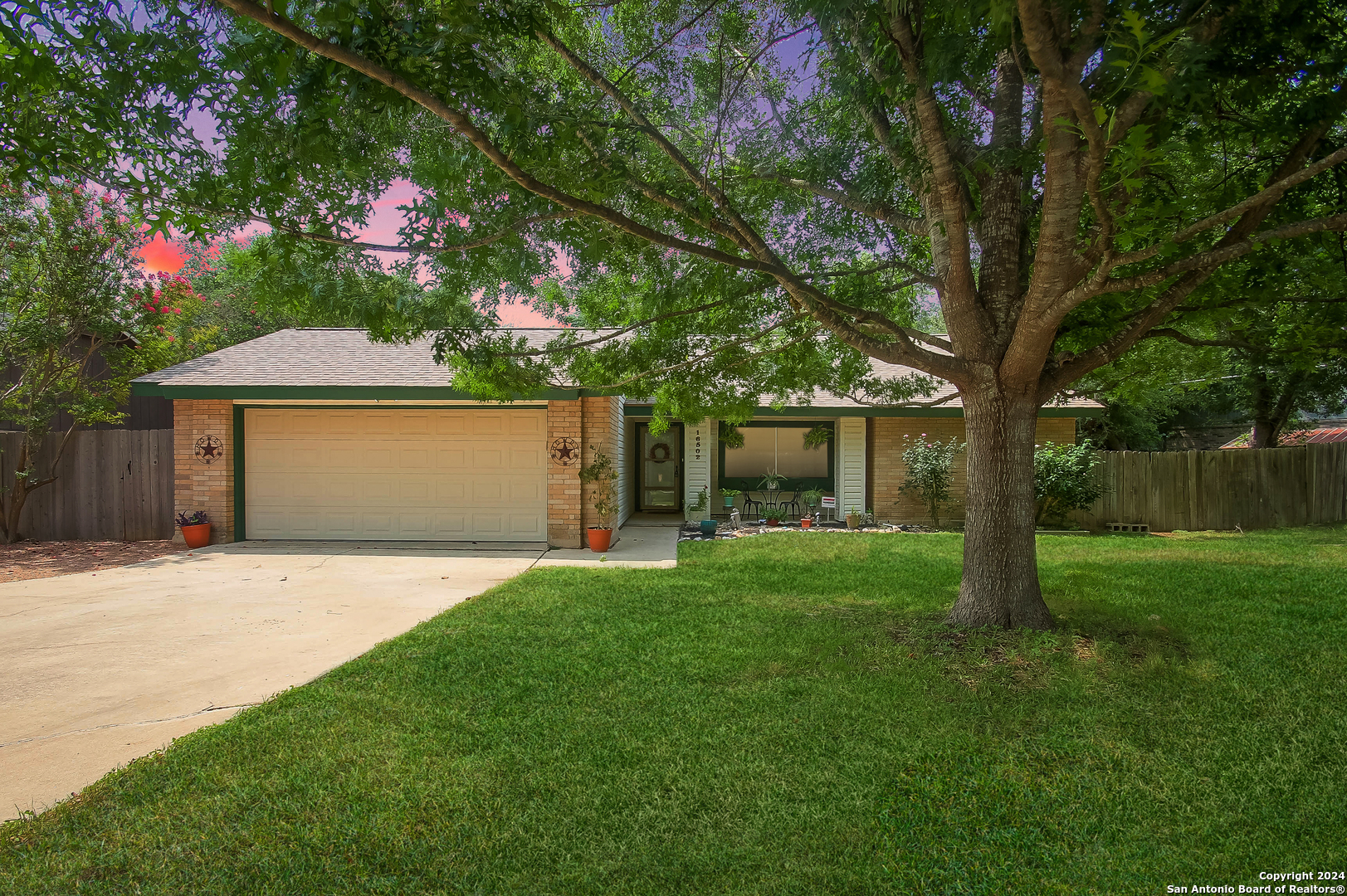 a front view of a house with a garden and yard