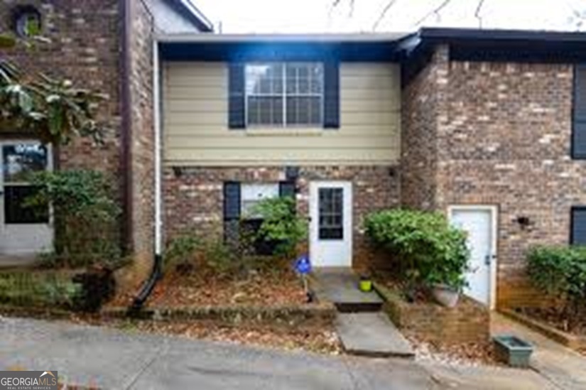 a view of a brick house with plants