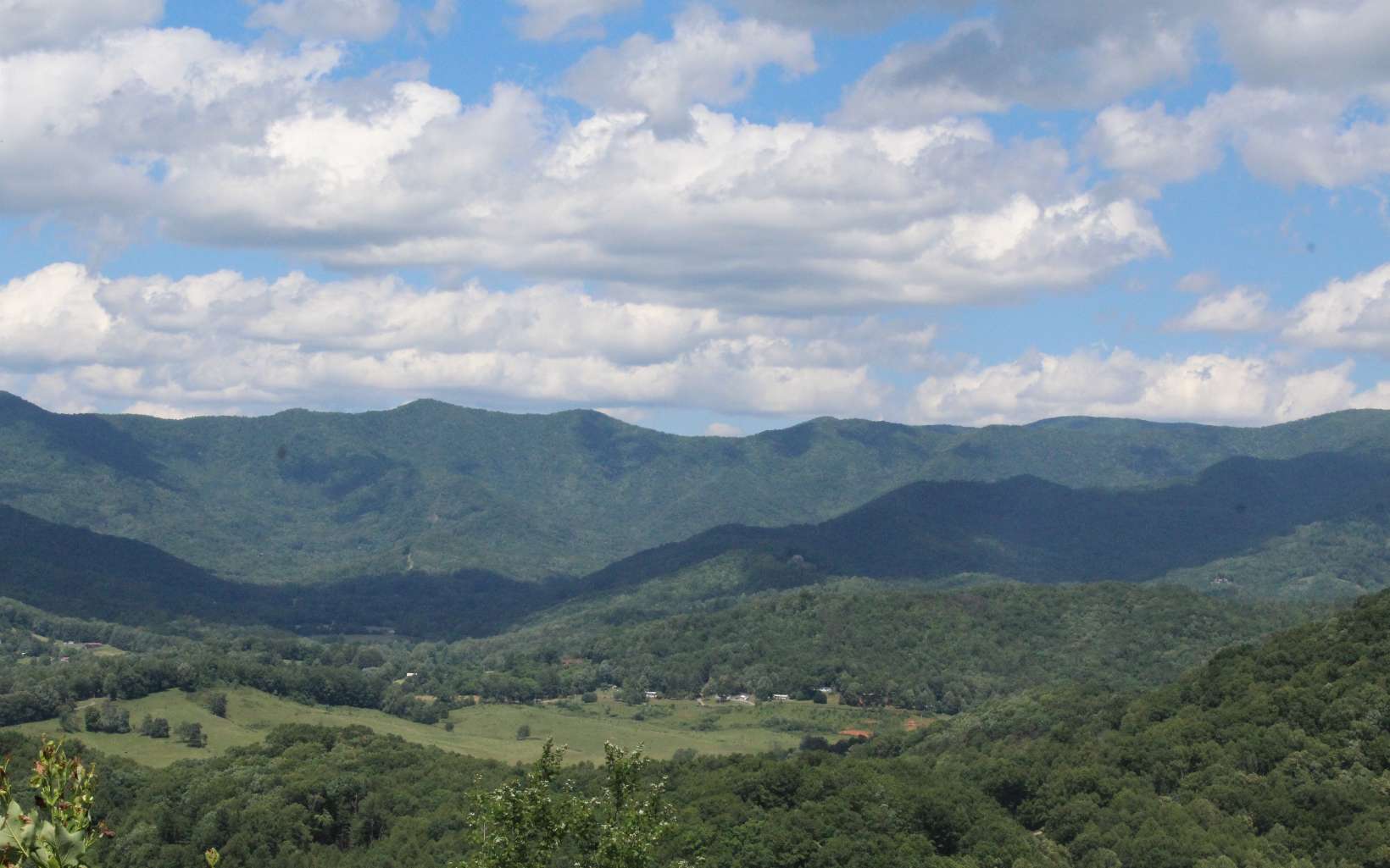 a view of a big yard with mountains in the background